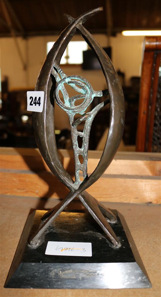 An abstract bronze sculpture, black stone base